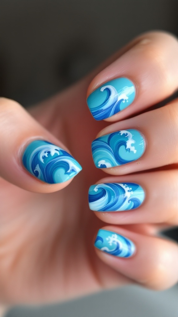 19 Simple Summer Nail Designs Best to Try in 6 Close-up of a hand with ocean wave patterned nails resting on sand.